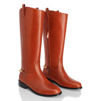 Par de botas altas color tan de Regina Romero con caña recta y suela baja en fondo claro