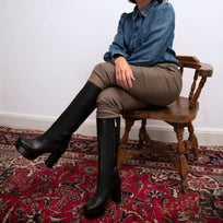Modelo luciendo botas altas de piel color negro Valquiria de Regina Romero