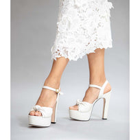 Look de novia mostrando sandalias blancas de plataforma con vestido largo