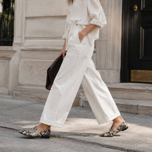 Toma de piernas cruzadas con mocasines de animal print combinados con pantalón oscuro