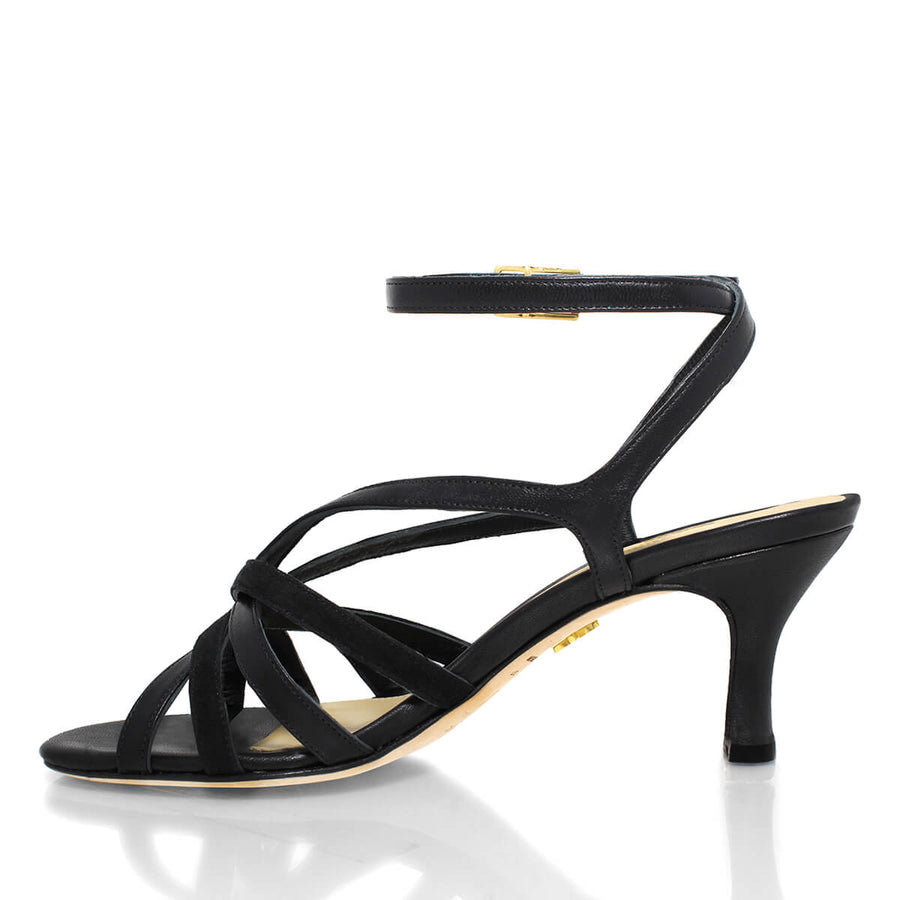 Perfil lateral opuesto de sandalias color negro con pulsera al tobillo y talón abierto