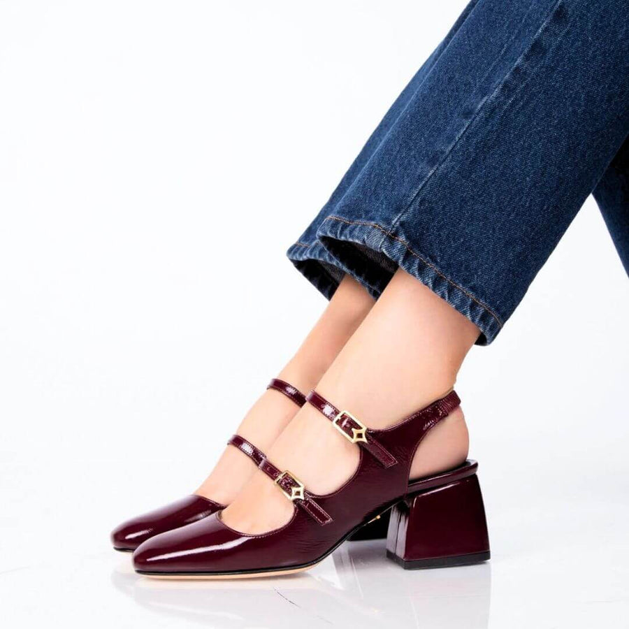 Detalle lateral de la zapatilla de charol vino con doble hebilla dorada Regina Romero Alessia