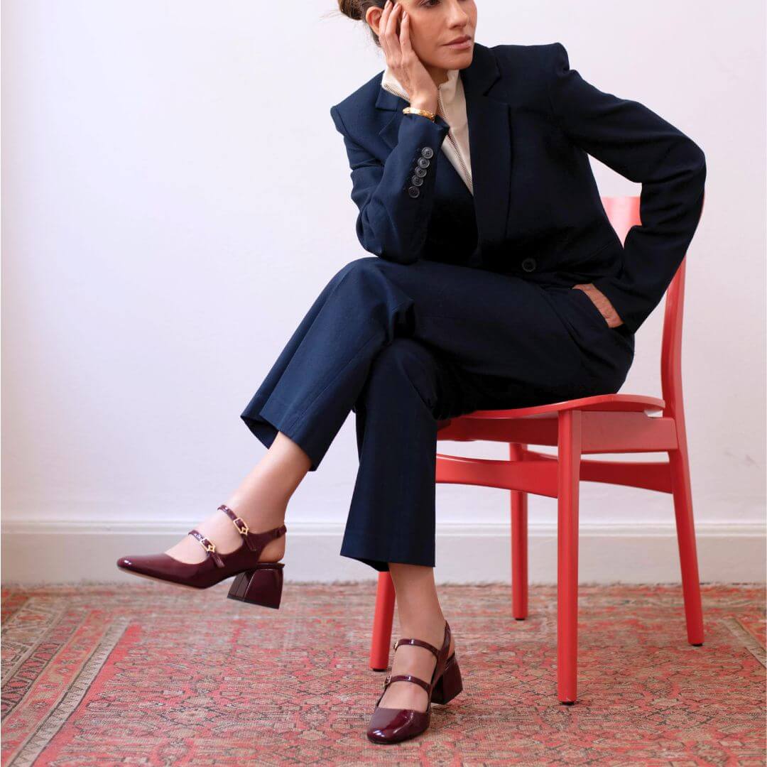 Mujer usando zapatillas de charol vino modelo Alessia de Regina Romero con pantalón elegante