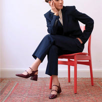 Mujer usando zapatillas de charol vino modelo Alessia de Regina Romero con pantalón elegante