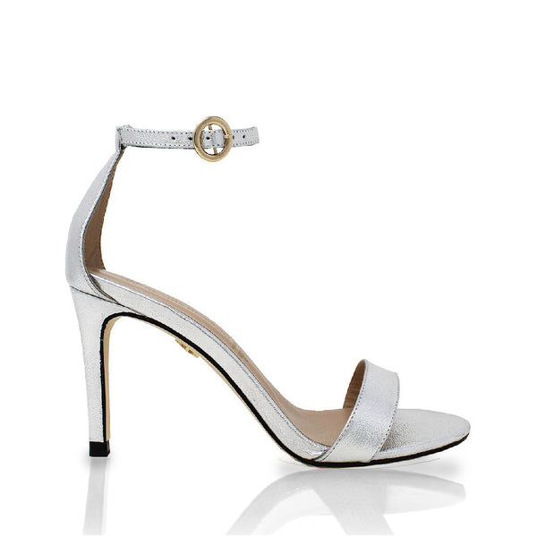 Vista lateral de sandalias de piel color plata con pulsera al tobillo, modelo Claudine de Regina Romero